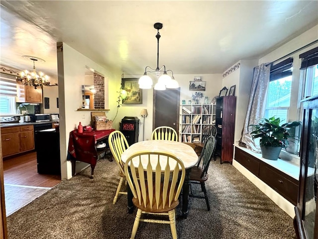 dining area featuring a chandelier and dark colored carpet