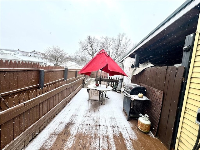 deck with outdoor dining space, a fenced backyard, and grilling area