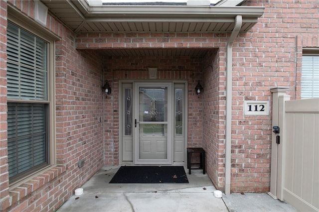 entrance to property featuring brick siding