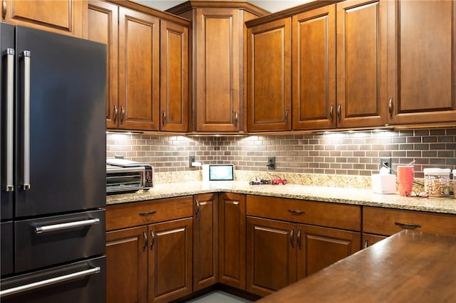 kitchen with tasteful backsplash, a toaster, brown cabinets, and high end refrigerator