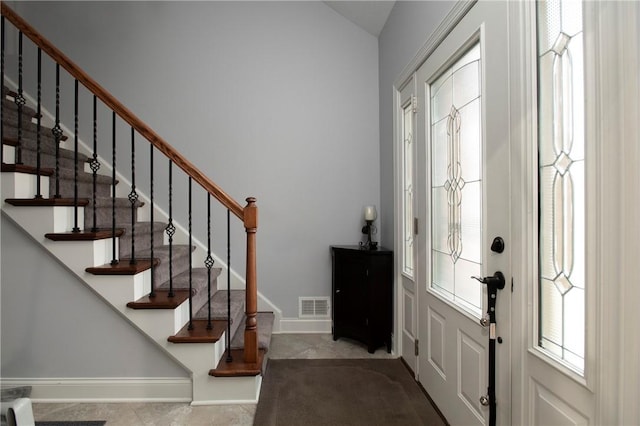 foyer entrance with visible vents and baseboards