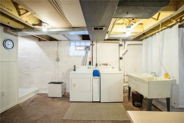 laundry room with washing machine and dryer, laundry area, visible vents, and a sink