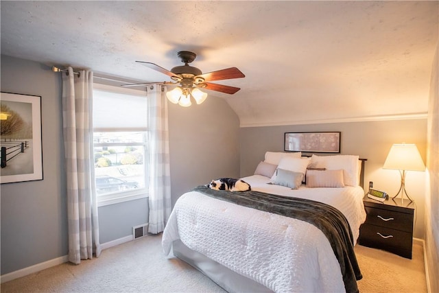 bedroom with ceiling fan, lofted ceiling, light colored carpet, visible vents, and baseboards