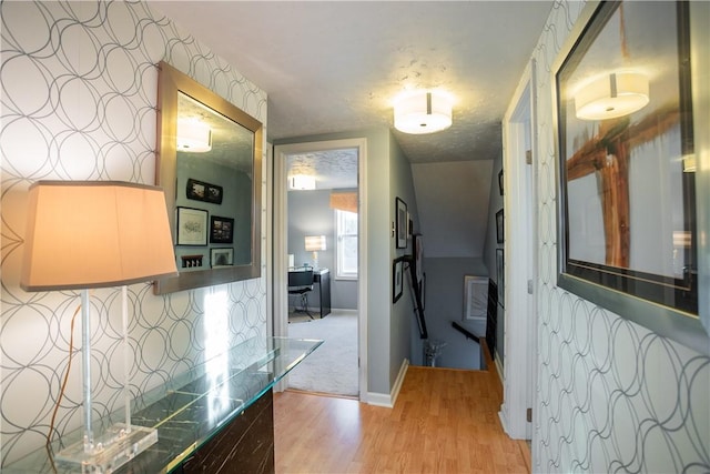 hall with baseboards and light wood-style floors