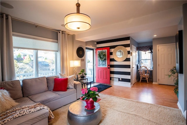 living area featuring a healthy amount of sunlight, baseboards, and wood finished floors