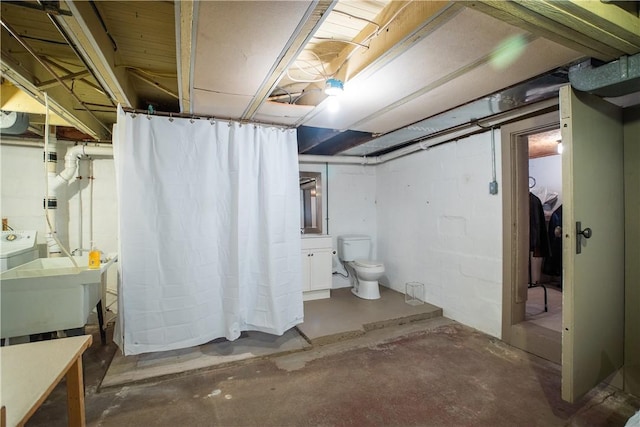 unfinished below grade area featuring independent washer and dryer and a sink