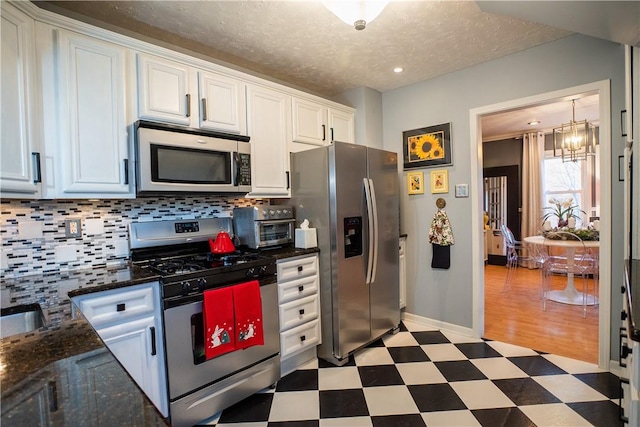 kitchen featuring light floors, appliances with stainless steel finishes, backsplash, and white cabinetry