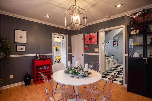 dining space with light floors, baseboards, ornamental molding, and a notable chandelier