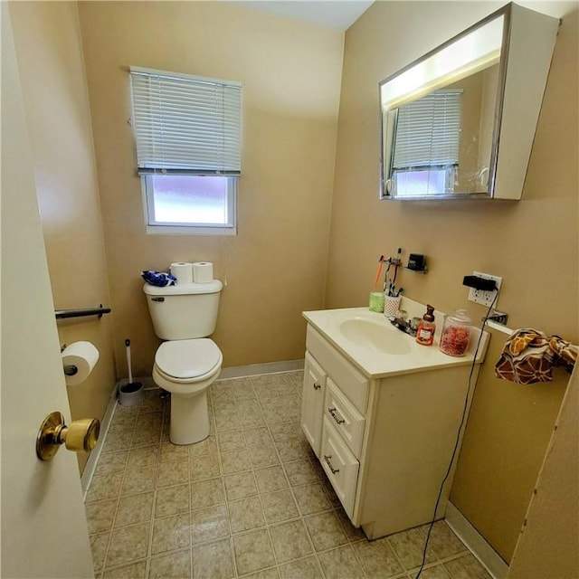 bathroom with tile patterned floors, vanity, toilet, and baseboards