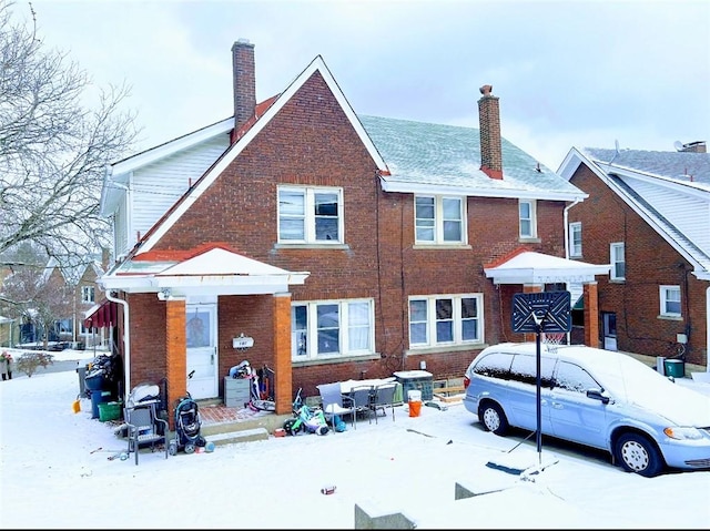 view of front facade featuring brick siding and a chimney