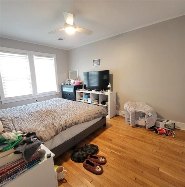 bedroom with ceiling fan, light wood-type flooring, and baseboards