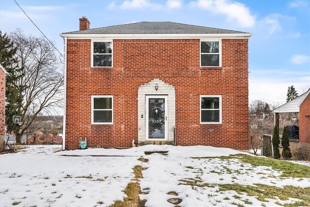 view of front of property with a chimney and brick siding