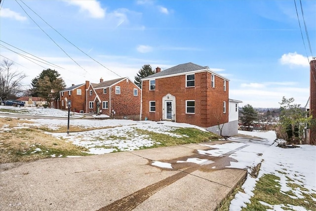 exterior space featuring a chimney and brick siding