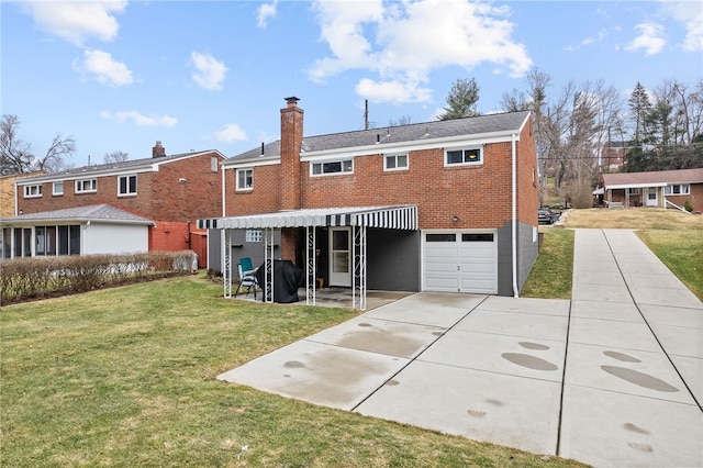 rear view of house with an attached garage, brick siding, a yard, driveway, and a chimney