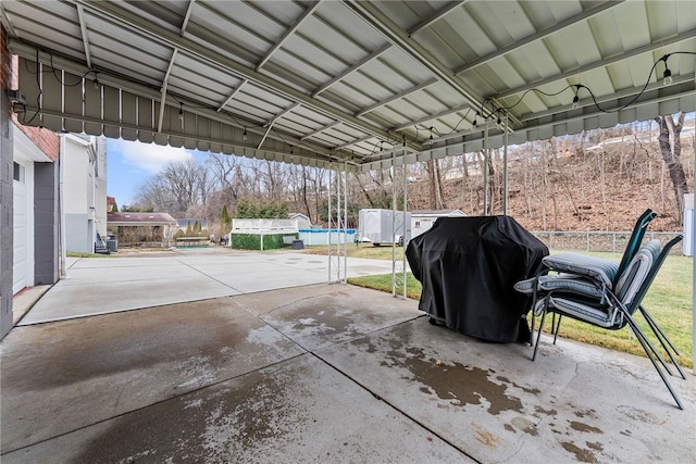 view of patio with a carport, a pool, and area for grilling