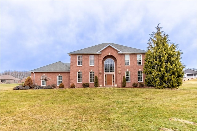 view of front of house with brick siding and a front yard