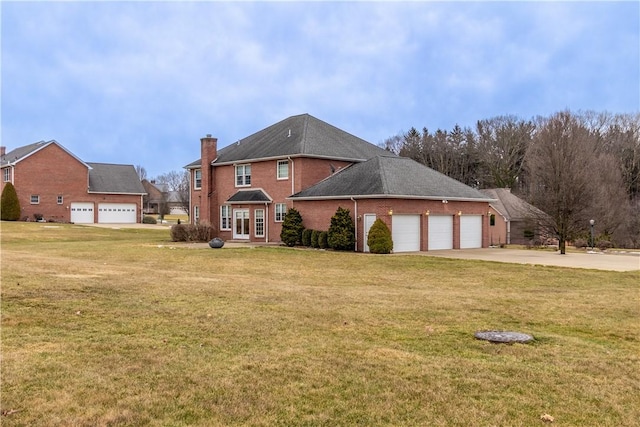 view of front of property with brick siding, driveway, a chimney, and a front lawn