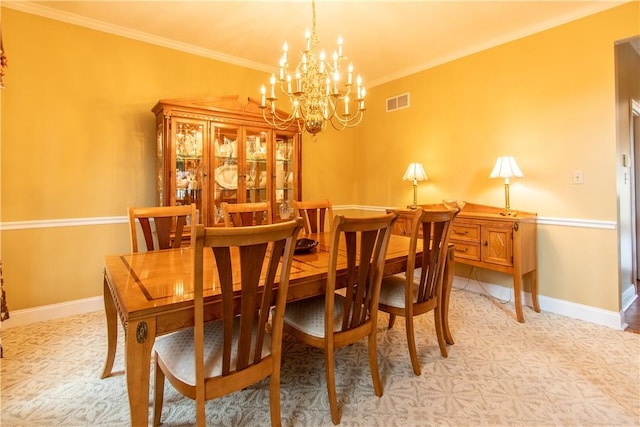 dining room featuring baseboards, visible vents, a chandelier, and ornamental molding