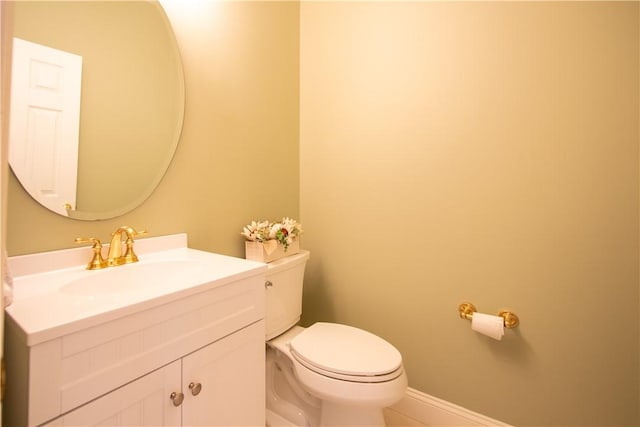 bathroom with baseboards, vanity, and toilet