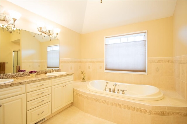 full bathroom featuring double vanity, a garden tub, tile patterned flooring, and a sink