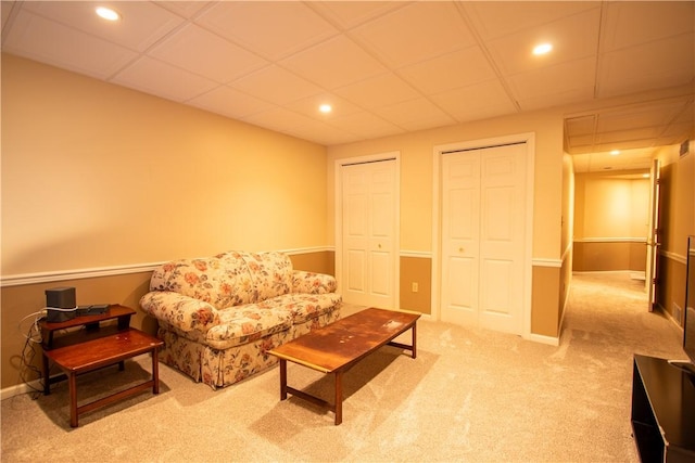 carpeted living room with a paneled ceiling, baseboards, and recessed lighting