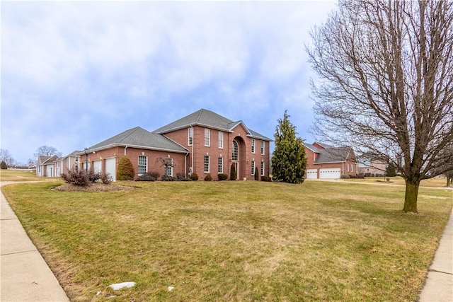 view of front of property featuring a front lawn, brick siding, and a garage
