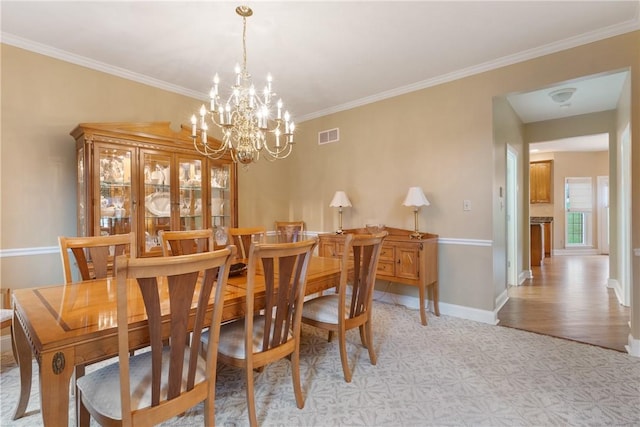 dining space with a chandelier, visible vents, baseboards, ornamental molding, and light floors