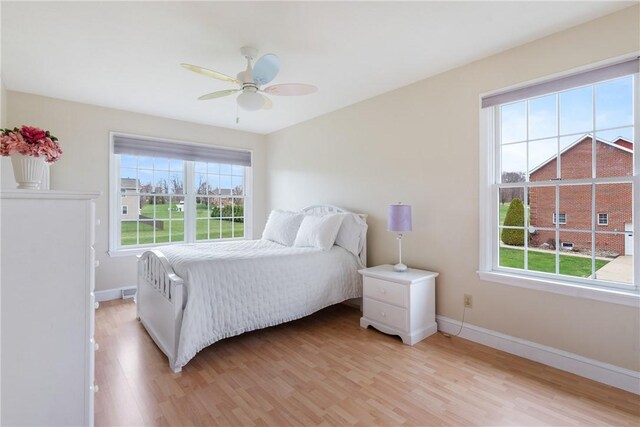 bedroom featuring baseboards, ceiling fan, and light wood-style floors