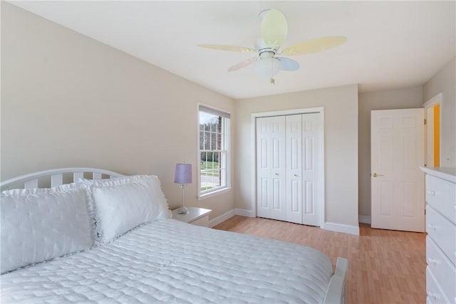 bedroom with a closet, light wood-style flooring, and baseboards