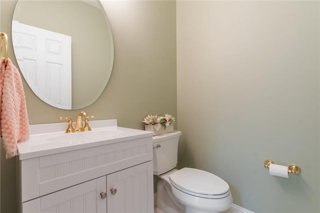 bathroom featuring baseboards, toilet, and vanity