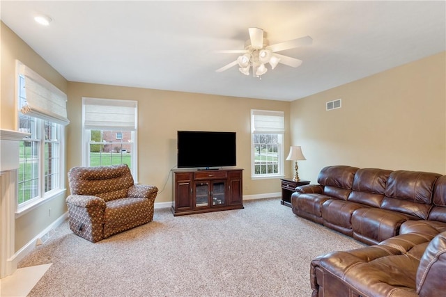 living area featuring a ceiling fan, visible vents, carpet floors, and baseboards