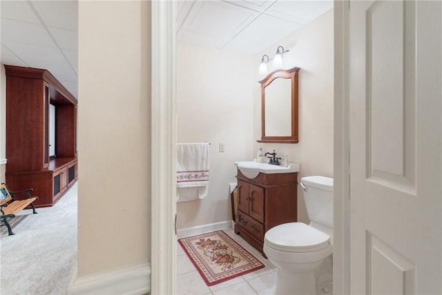 half bath featuring vanity, toilet, and tile patterned flooring