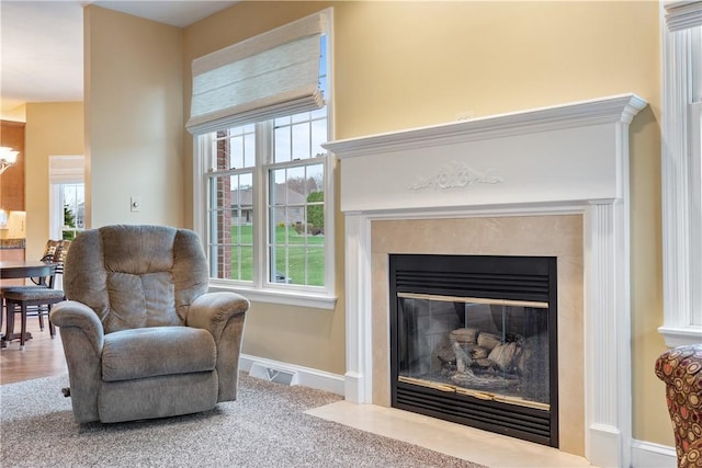 sitting room with a chandelier, a fireplace, visible vents, baseboards, and carpet floors