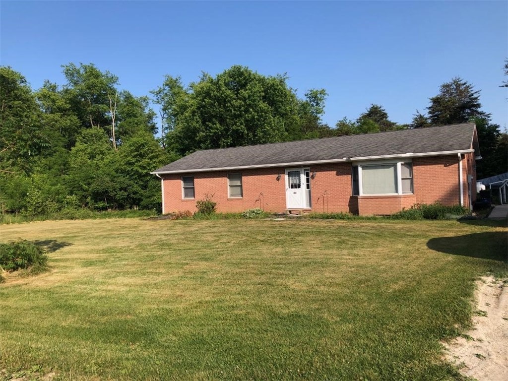 single story home with brick siding and a front yard