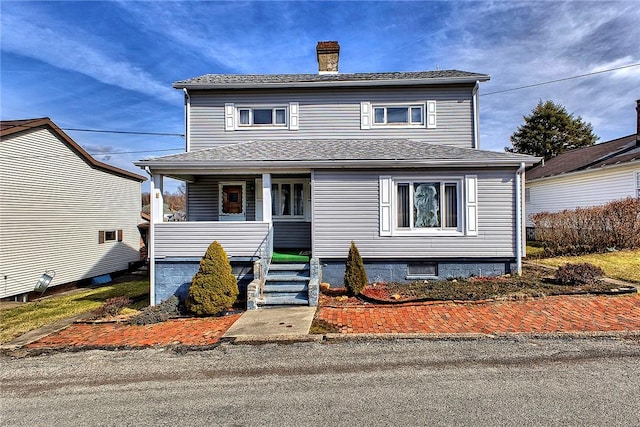 view of front of home with a porch, a shingled roof, and a chimney