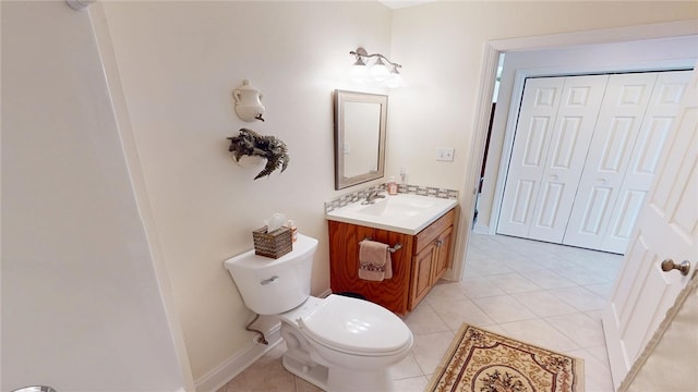 bathroom featuring toilet, baseboards, vanity, and tile patterned floors