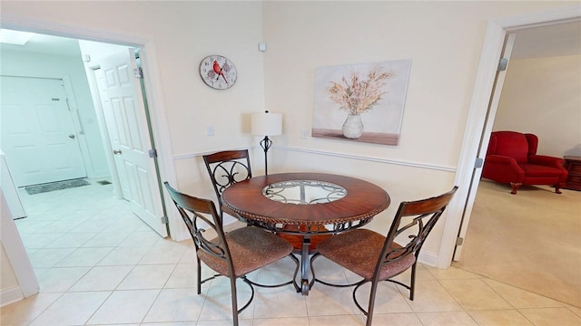 dining area featuring light carpet and light tile patterned flooring