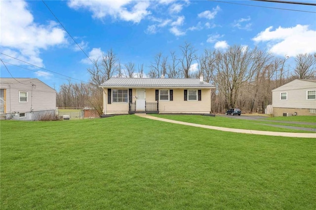 view of front of home featuring a porch, a front yard, metal roof, and a chimney