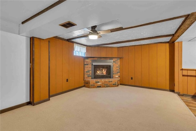 129 Birch St, Brighton Twp, PA 15009 - unfurnished living room with a fireplace, beam ceiling, wooden walls, a ceiling fan, and light colored carpet