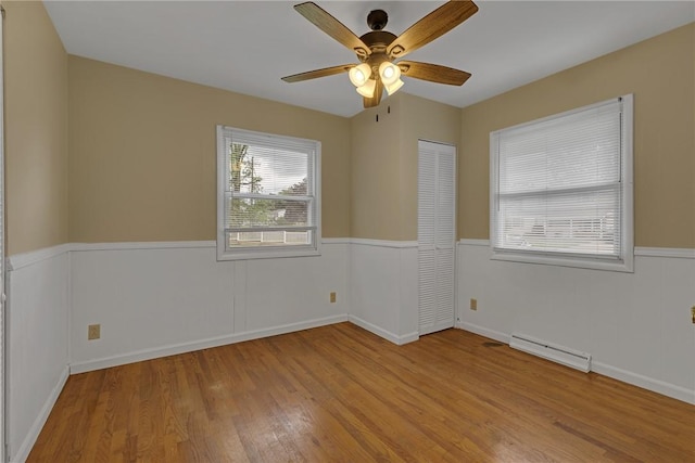 129 Birch St, Brighton Twp, PA 15009 - unfurnished room featuring wood finished floors, a baseboard radiator, ceiling fan, and wainscoting