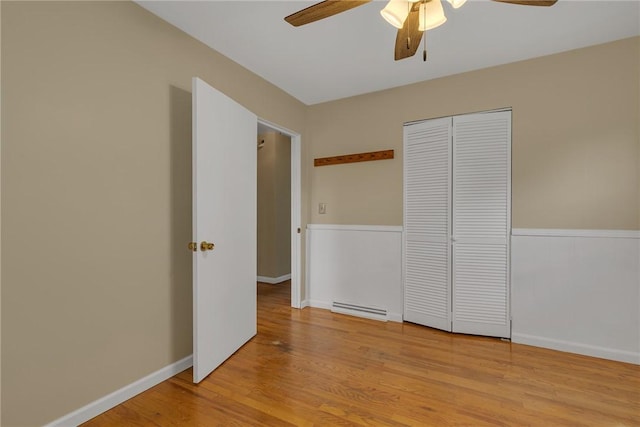 129 Birch St, Brighton Twp, PA 15009 - unfurnished bedroom featuring baseboard heating, light wood-style floors, a closet, a ceiling fan, and baseboards