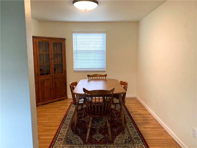 dining room with light wood-type flooring and baseboards