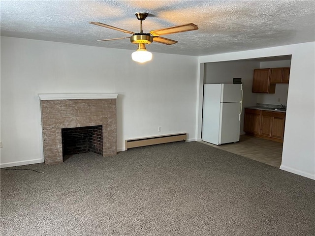 unfurnished living room featuring a baseboard heating unit, light colored carpet, a fireplace, and ceiling fan