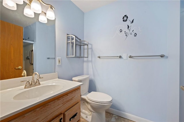 bathroom featuring toilet, vanity, and a shower with shower door