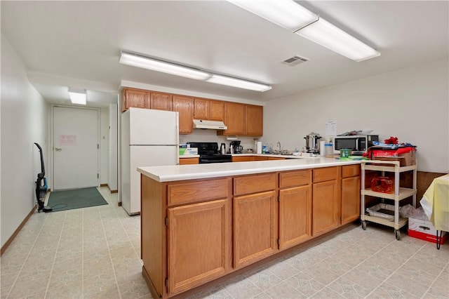 kitchen with light countertops, freestanding refrigerator, black stove, a peninsula, and under cabinet range hood