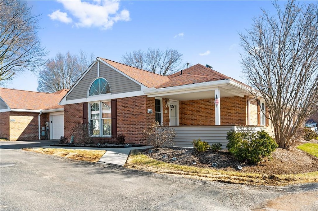 single story home featuring an attached garage, driveway, and brick siding