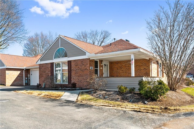 single story home featuring an attached garage, driveway, and brick siding