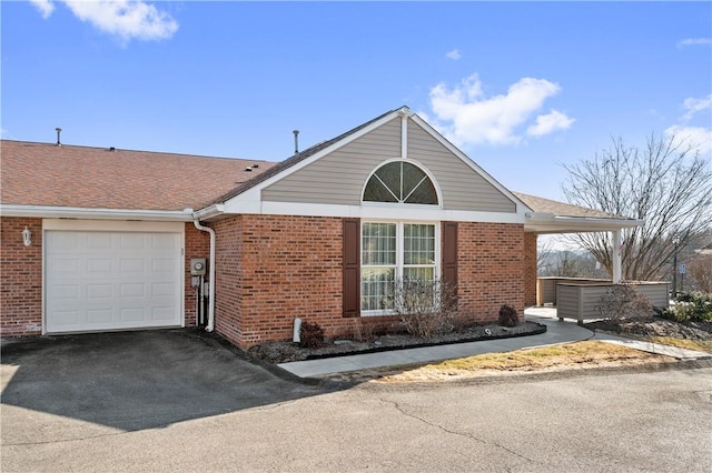 view of front of home featuring aphalt driveway, brick siding, a garage, and roof with shingles