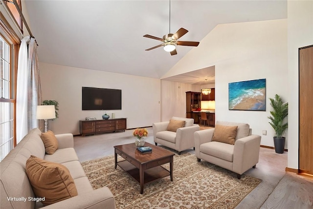 carpeted living room featuring ceiling fan, high vaulted ceiling, and baseboards