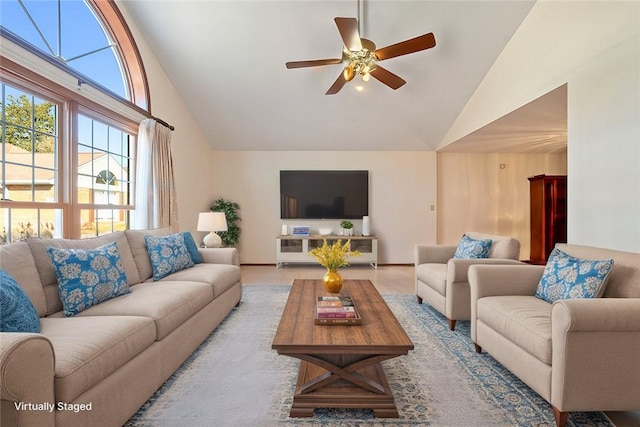 living area featuring high vaulted ceiling and a ceiling fan